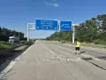 Uszkodzona autostrada A2 Niemcy. Na drodze leżą gruzy, a pracownik w kamizelce odblaskowej ogląda zniszczenia.