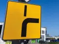 Żółty znak drogowy informuje o drodze z pierwszeństwem łamanym, gdzie główna droga skręca w prawo.
