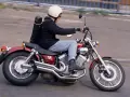 Motocyklista na czerwonym Yamaha Virago 535, z futerałem na instrumenty z tyłu. Dane techniczne tego modelu są imponujące.