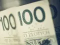 Sto złotych na zakup motocykla. Widoczne fragmenty banknotów 100 zł.