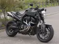 Czarny Yamaha MT-01 z customowym wydechem i sportowymi dodatkami, gotowy na jazdę po krętych drogach.