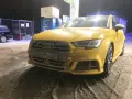 Żółte Audi na stacji benzynowej, pokryte błotem i śniegiem. Nieczytelna tablica rejestracyjna utrudnia identyfikację.