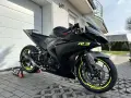 Czarny motocykl Yamaha R3 z żółtymi akcentami na felgach i owiewkach. Widać sportowy wydech Yoshimura. Idealny do poznania yamaha r3 dane techniczne.