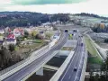 Nowa zakopianka trasa z tunelami i wiaduktami, otoczona lasami i zabudowaniami.
