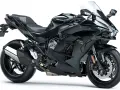 Czarny motocykl Kawasaki H2 Ninja, z widocznym napisem "Supercharger" na silniku. Potężna maszyna gotowa do podboju dróg.