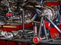 Motocykl na stojaku, widoczny napęd i łańcuch. Puszka smaru Motul sugeruje, co ile smarować łańcuch w motocyklu.