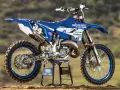 Niebiesko-biały motocykl Yamaha YZ 125 na stojaku. Ile koni ma Yamaha YZ 125? Ten model to potężna maszyna terenowa.