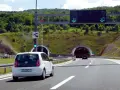 W Chorwacji są płatne autostrady. Biały samochód zbliża się do tunelu, sygnalizacja świetlna zielona.