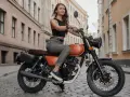 Kobieta na motocyklu 125cc, gotowa na jazdę po mieście. Bezpieczeństwo przede wszystkim, nawet po 3 latach od zakupu.