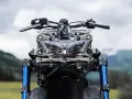 Przód motocykla Yamaha Niken GT z niebieskimi lagami i charakterystycznym, wielopunktowym reflektorem.
