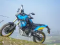Niebiesko-żółty motocykl Yamaha Tenere 700 Rally gotowy na przygodę na wzgórzu.
