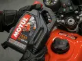 Rękawice motocyklisty trzymają olej Motul 7100 10W-40. Pytanie: co ile wymieniać olej w motocyklu?
