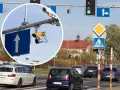 Zbliżenie na kamery monitoringu przy drogowskazie z białym strzałką w górę.