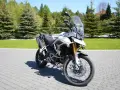 Biały motocykl Triumph Tiger 900 na brukowanej nawierzchni. Poznaj jego imponujące triumph tiger 900 dane techniczne.