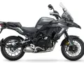 Szary motocykl Benelli TRK 502 z czarnym siedzeniem i bagażnikiem, gotowy na przygodę.