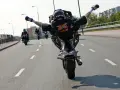 Motocyklista wykonuje jazdę na jednym kole, rozkrokiem. Ryzykowne wyczyny mogą skończyć się mandatem.