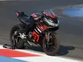 Czarna Aprilia RS 125 2T V-Max na torze wyścigowym, gotowa do osiągnięcia maksymalnej prędkości.
