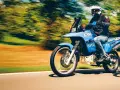 Motocyklista na niebieskim Suzuki DR 800 Big pędzi po drodze. Poznaj suzuki dr 800 big dane techniczne i poczuj wolność.