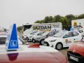Auta szkoleniowe z literą "L" na dachu, gotowe do nauki różnych kategorii prawa jazdy.
