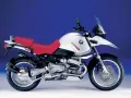 Srebrny motocykl BMW R 1150 GS z czerwoną kanapą, gotowy na przygodę.