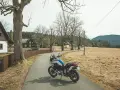 Motocykl czeka na przygodę na malowniczej drodze. Idealne miejsce na odkrywanie tras motocyklowych w Czechach.