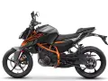 Szary motocykl KTM Duke 390 z pomarańczowymi akcentami, gotowy do osiągnięcia maksymalnej prędkości.