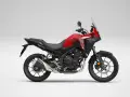 Czerwony motocykl Honda NX 500 z czarnymi elementami, gotowy na przygodę.