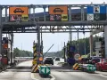Pobieranie opłat na autostradzie A4. Samochody zbliżają się do bramek, na których wyświetlane są informacje o opłatach.