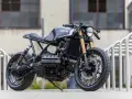 Czarny motocykl BMW K100 w stylu cafe racer, stojący na zewnątrz.