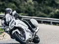 Motocyklista w kasku pochyla się na białym motocyklu Yamaha FJR 1300, pokonując zakręt. Dane techniczne tego modelu są imponujące.