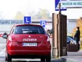 Czerwony samochód z literą "L" na dachu i napisem "EGZAMIN" czeka przed bramą. Czy trudno zdać prawo jazdy?