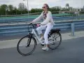 Młoda kobieta na rowerze elektrycznym, zastanawia się, czy na rower elektryczny trzeba mieć prawo jazdy.