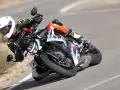 Motocyklista w kombinezonie i kasku pochyla się na zakręcie na sportowym motocyklu BMW. DTC BMW zapewnia kontrolę.