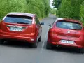 Dwa czerwone auta jadą drogą. Jedno z nich, Ford Focus, próbuje omijanie, podczas gdy Seat Leon wykonuje wymijanie.
