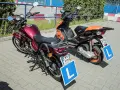 Dwa pojazdy, motorower i skuter, gotowe do nauki jazdy. Na każdym z nich widnieje tablica z literą "L", symbolizująca kartę motorowerową.