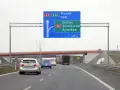 Autostradą A2 w kierunku Poznania i Łodzi. Znak informuje o minimalnej prędkości na autostradzie i zjeździe na Grójec, Sochaczew, Żyrardów za 500 m.
