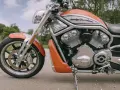 Pomarańczowy Harley-Davidson z serii V-Rod, potężny muscle bike, gotowy na jazdę.