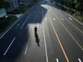 Samotny motocyklista na pustej drodze, cień rzuca się na asfalt. Zastanawia się, jak wyrejestrować skuter.