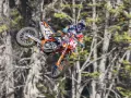 Motocyklista w powietrzu na pomarańczowym crossie z numerem 84. To są najlepsze crossy, jakie można zobaczyć!