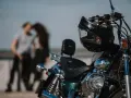 Motocykl z kaskiem na kierownicy, w tle para w czułym uścisku. Idealny dzień na wspólną podróż 4t.