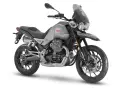 Srebrny motocykl Moto Guzzi V85 TT z charakterystycznym silnikiem V-twin, gotowy na przygodę.