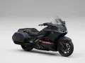 Ciemnoszary motocykl Honda Gold Wing z czarnym siedzeniem i kuframi, gotowy na dalekie podróże.