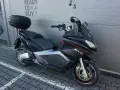 Czarny skuter Aprilia SRV 850 z kufrem, gotowy do zakupu.