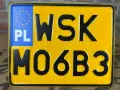 Żółta tablica rejestracyjna z oznaczeniem PL i numerem WSK M06B3.