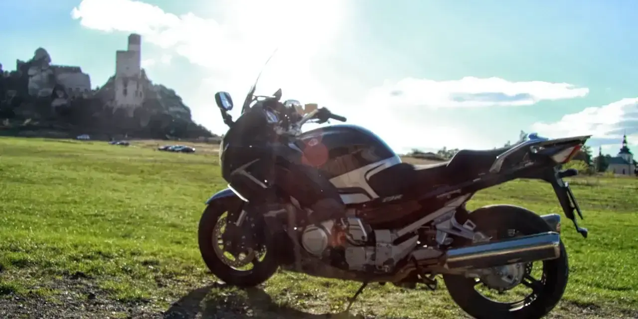 Motocykl na tle zamku w skale. Idealny kompan na podróż po Jurze Krakowsko-Częstochowskiej.