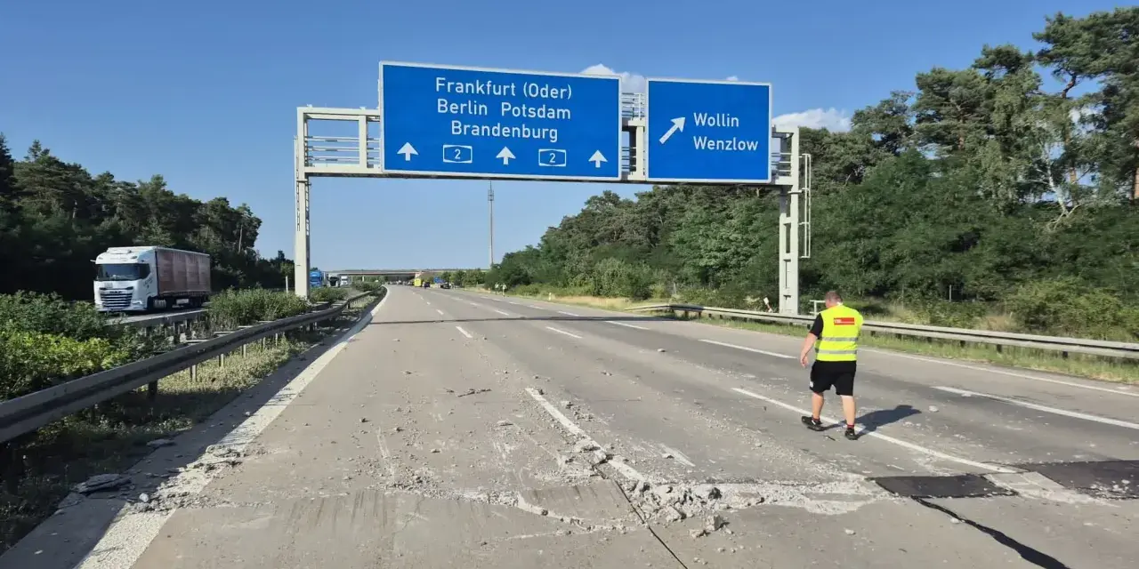 Uszkodzona autostrada A2 Niemcy. Na drodze leżą gruzy, a pracownik w kamizelce odblaskowej ogląda zniszczenia.
