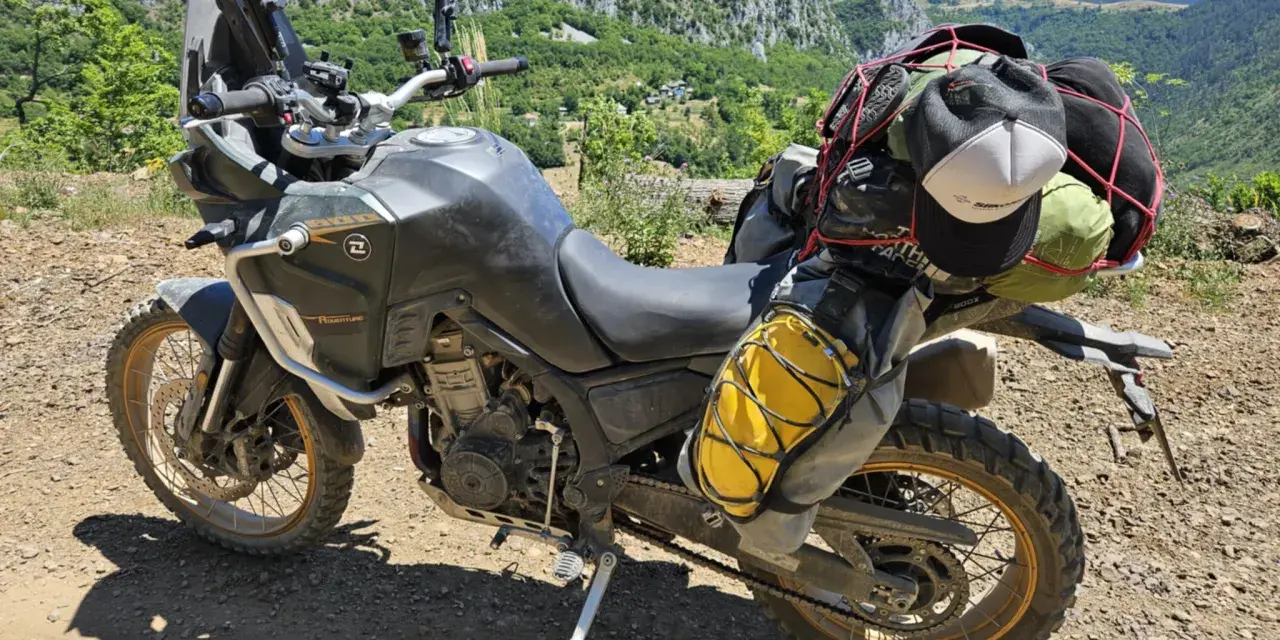 Motocykl Kove 800X Rally gotowy na przygodę, z bagażem na wyprawę po górskich drogach.