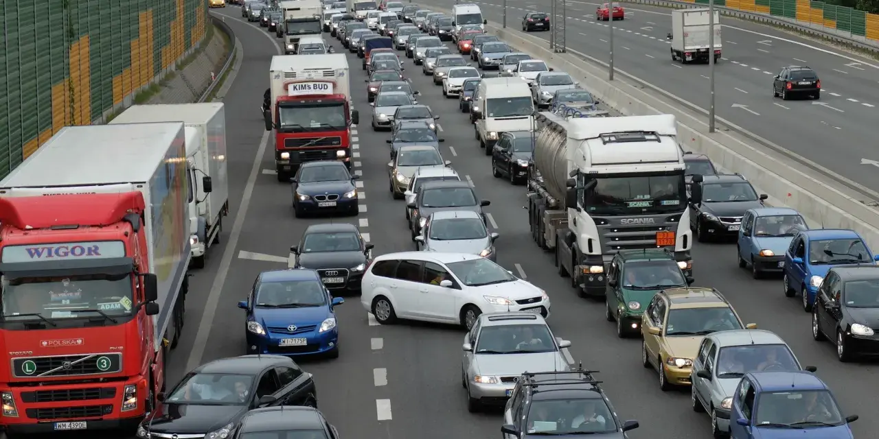 Korki na autostradzie, wiele samochodów i ciężarówek stoi w miejscu. Aktualne utrudnienia na drogach uniemożliwiają płynny ruch.