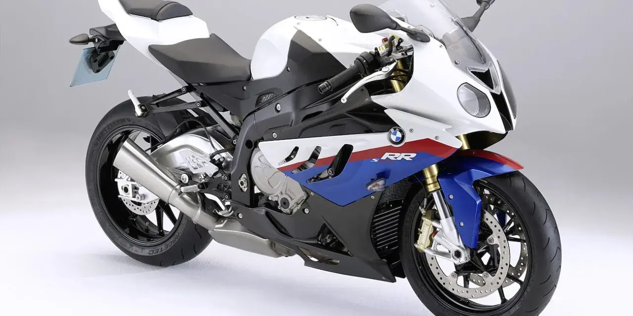 Sportowy motocykl BMW S1000RR 2018 w biało-niebiesko-czerwonych barwach, gotowy do podboju toru wyścigowego.