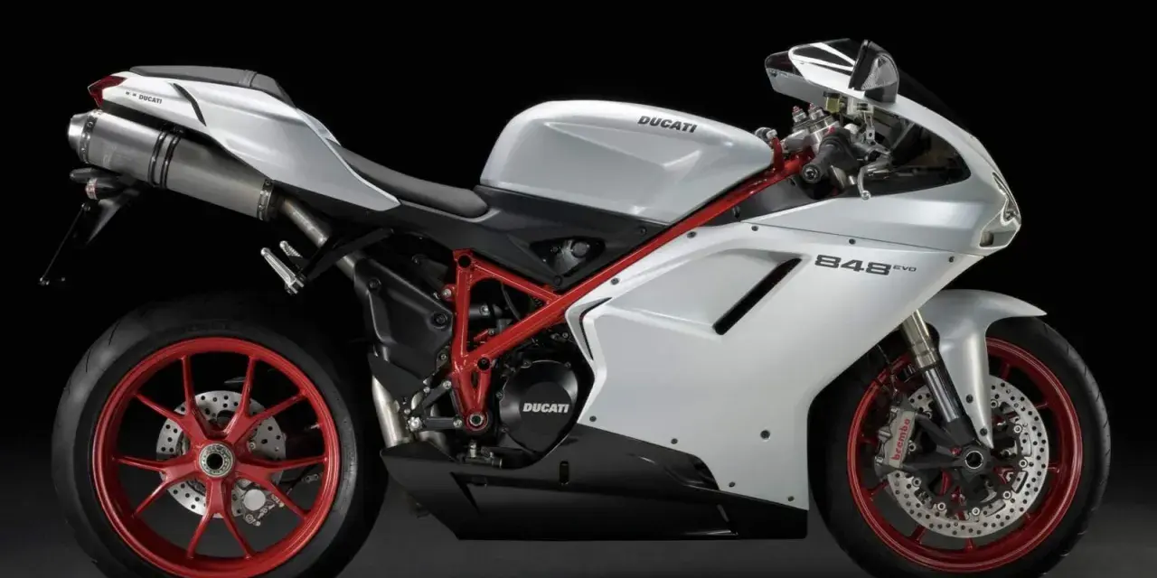 Biały motocykl Ducati 848 EVO z czerwonym stelażem i felgami, prezentujący sportowy design i moc.
